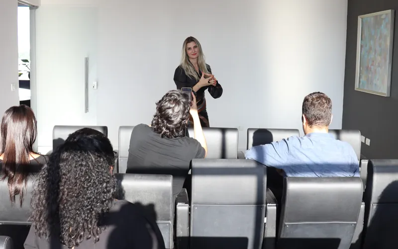 Dra. Jéssica conduzindo um treinamento presencial com equipe